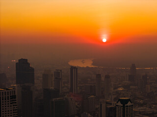Fototapeta premium Dramatic sunrise over Bangkok city skyline. High buildings silhouettes under beautiful red sky