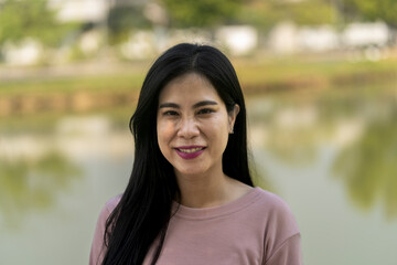 Portrait of smiling young beautiful woman at park