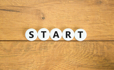 Start symbol. Concept word Start on beautiful white pills circles. Beautiful wooden table wooden background. Business lifestyle start concept. Copy space.