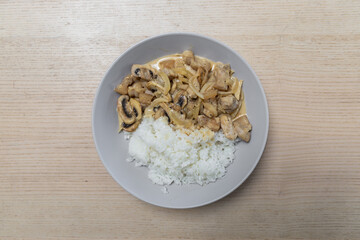 A plate of creamy pork and white rice.
