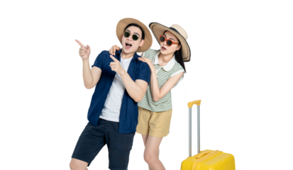 portrait of asian couple wearing travel clothes, suitcases and posing on white background