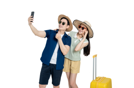 portrait of asian couple wearing travel clothes, suitcases and using phone  posing on white background