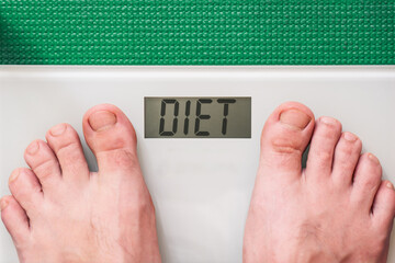 Man standing on a digital scale. Instead of showing a weight number, the screen humorously displays the word DIET &mdash; a concept image for health and motivation.