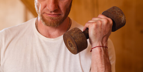 Man Lifting Weights in Wooden Home Gym During Bright Morning Workout