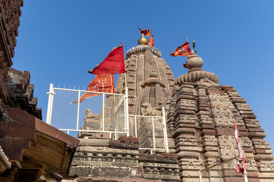 ancient hindu temple with waving holy flag and bright blue sky background from at morning