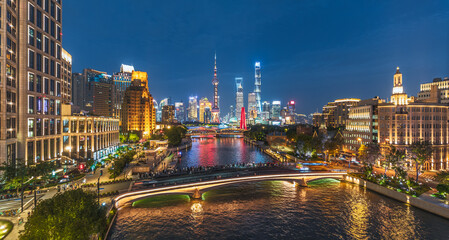 Fototapeta premium Night view of Shanghai cityscape with river, bridge, and skyline light.
