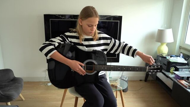 13 year old Teenager Girl Playing Guitar Indoor.