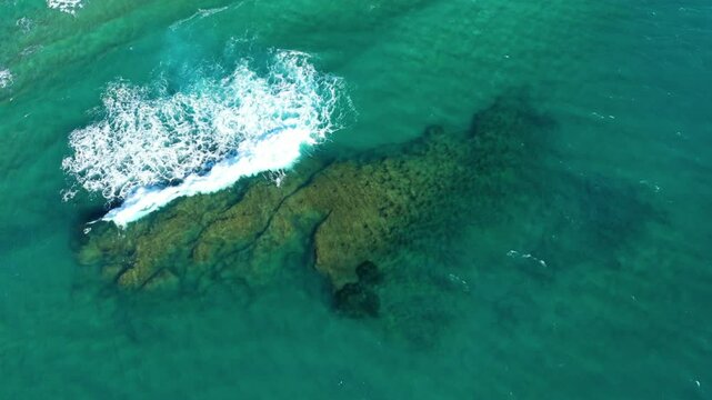 The wave hitting the rocks of Acciaroli in Europe, Italy, Campania, in summer, on a sunny day.&nbsp;