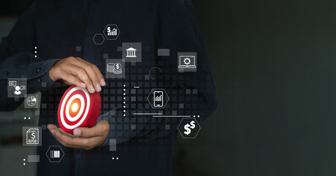 A man holds a target surrounded by digital business and finance icons.