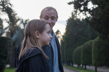 Fototapeta premium Family outdoors portrait. Young daughter child girl and her father walking outdoors. Happiness, childhood and bonding concept
