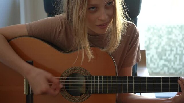 13 year old Teenager Girl Playing Guitar Indoor.