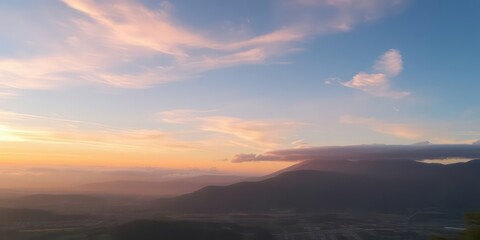 Serene Sunset Over a Distant Mountain Range and Rolling Hills