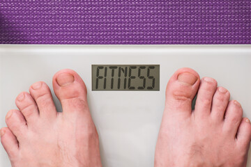Man standing on a digital scale. Instead of showing a weight number, the screen humorously displays the word FITNESS &mdash; a concept image for health and motivation.