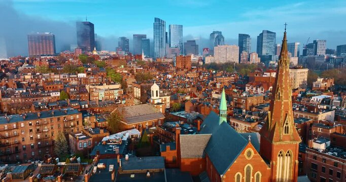 Flying above the bright architecture of Boston. District with multiple old-style buildings with orange facades. Downtown is coated with fog. Aerial perspective.