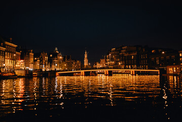 Night view of the illuminated Magere Brug (Skinny Bridge) over Amstel river in Amsterdam, Netherlands. © eduardpopik