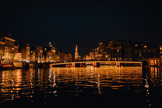 Night view of the illuminated Magere Brug (Skinny Bridge) over Amstel river in Amsterdam, Netherlands.