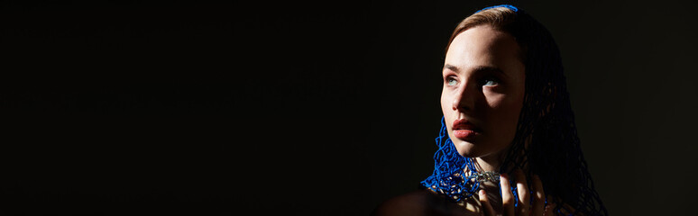 Expressive portrait of a young woman with captivating blue accents in a dramatic light setting