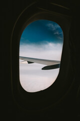 Commercial airplane wing, flying over cloudy weather. Passenger window point of view, no people