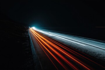 Dynamic light trails illuminate the night highway creating a sense of speed and modern transportation with abstract glowing lines and dark asphalt road from above