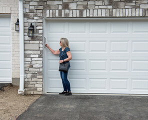 Woman Reaching to Punch in Code to Open Garage 