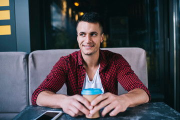 Smiling man having coffee break in cafe