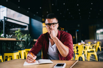 Serious male freelance working in cafe