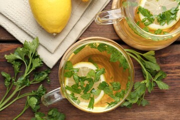 Healthy parsley tea with lemon slices on wooden table, flat lay. Detox drink