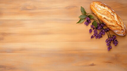 Fototapeta premium Crusty Bread Loaf and Purple Flowers on Wooden Table
