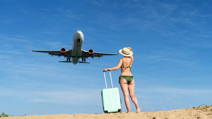 A woman on the beach by the sea with a suitcase. Meets and escorts the plane