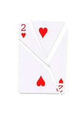 A playing card in the suit of hearts cut into sharp pieces.