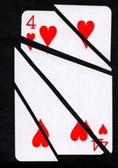A playing card in the suit of hearts cut into sharp pieces.