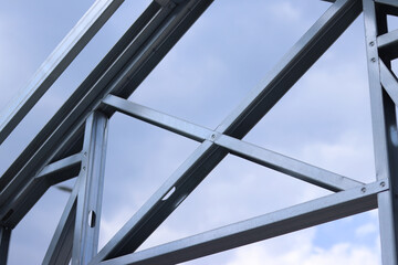 Lightweight steel thin-walled structures. Frames for warehouses, garages or houses. Structure of a steel frame for construction against the sky