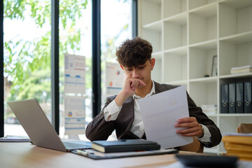 Fototapeta premium Thoughtful businessmman reading financial report at office desk.