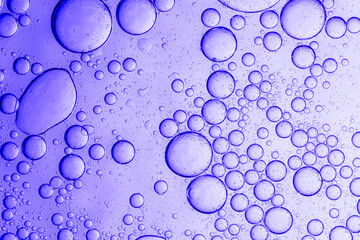 Texture, background, purple cosmetic bubbles macro,Liquid serum gel texture, oil drops on lavender color background. Clear skincare cosmetic product swatch with bubbles closeup