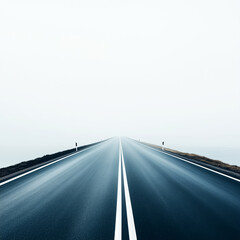 A long, empty road disappears into mist, symbolizing freedom and adventure ahead in a tranquil landscape.
