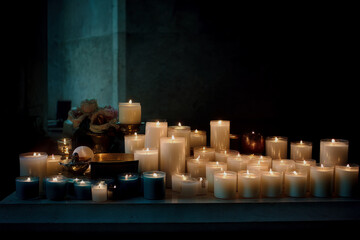 Burning votive candles, flowers and rosary for funeral ceremony in church