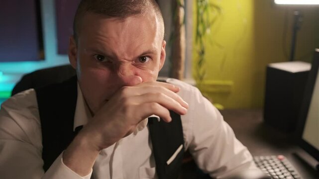 man in his home office reacting to a bad smell. The mans expression of disgust and his reaction of covering his nose with his hand are clear indicators that he is experiencing something unpleasant.