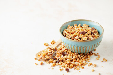 Tasty crispy granola in bowl on white background. Healthy breakfast. Copy space