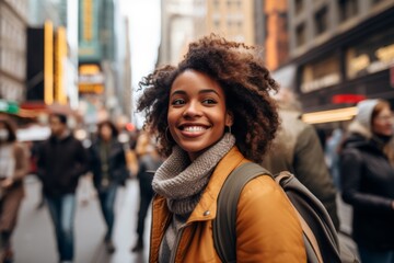 Fototapeta premium Portrait of a smiling young African American woman in city