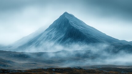 Misty peak, dramatic mountain landscape in cool tones.