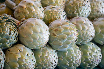 A bunch of green vegetables, including artichokes