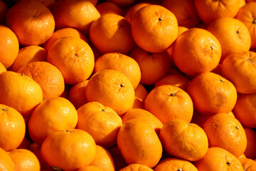 A bunch of oranges are piled up on top of each other