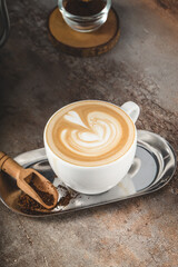Close-up of a beautifully crafted latte art in a white ceramic cup, featuring a delicate swirl-tulip design.