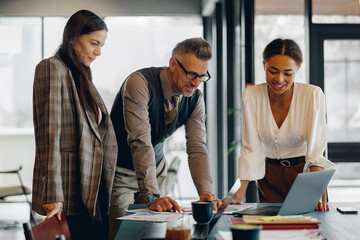 A group of professionals actively collaborating on a project within a modern, contemporary office...