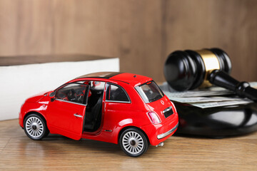 Motor vehicle accident law. Gavel, money and car model on wooden background, closeup