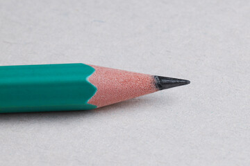 One sharp graphite pencil on light background, closeup