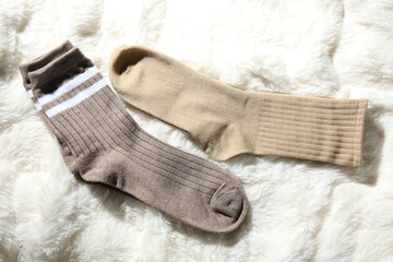 Soft socks on white faux fur, top view