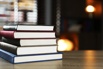 Stack of books on wooden table indoors. Space for text