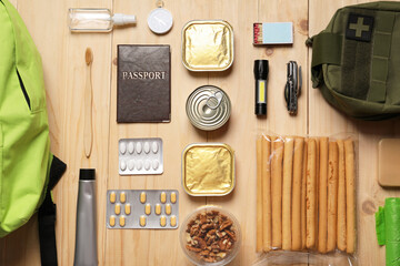 Survival kit. Different emergency supplies on wooden table, flat lay