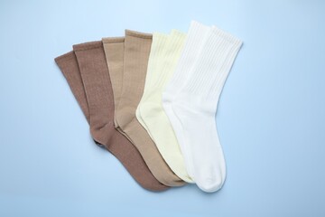 Many different pairs of socks on light blue background, top view